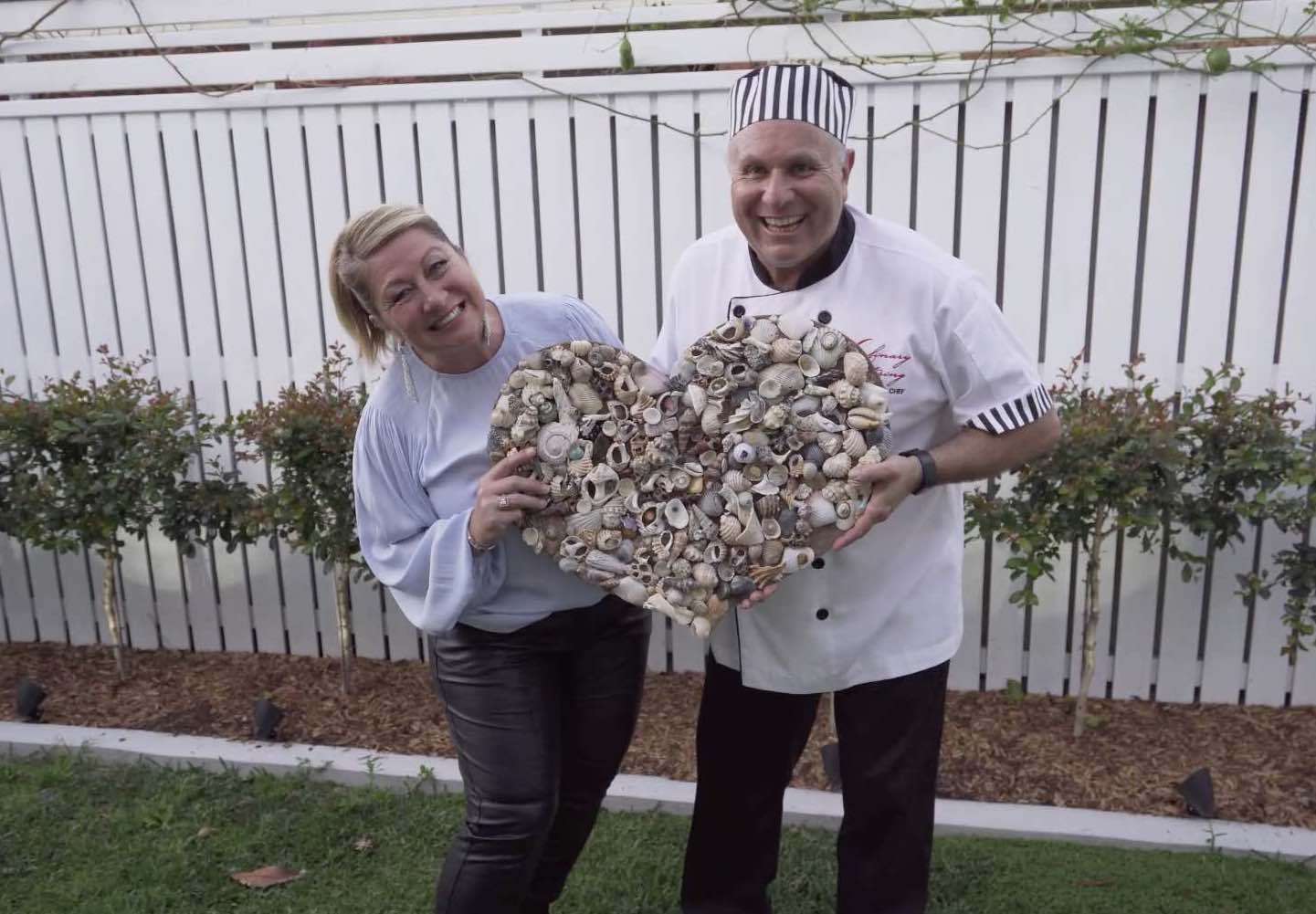 Culinary Catering Owners Lisa and Paul holding big wooden love heart