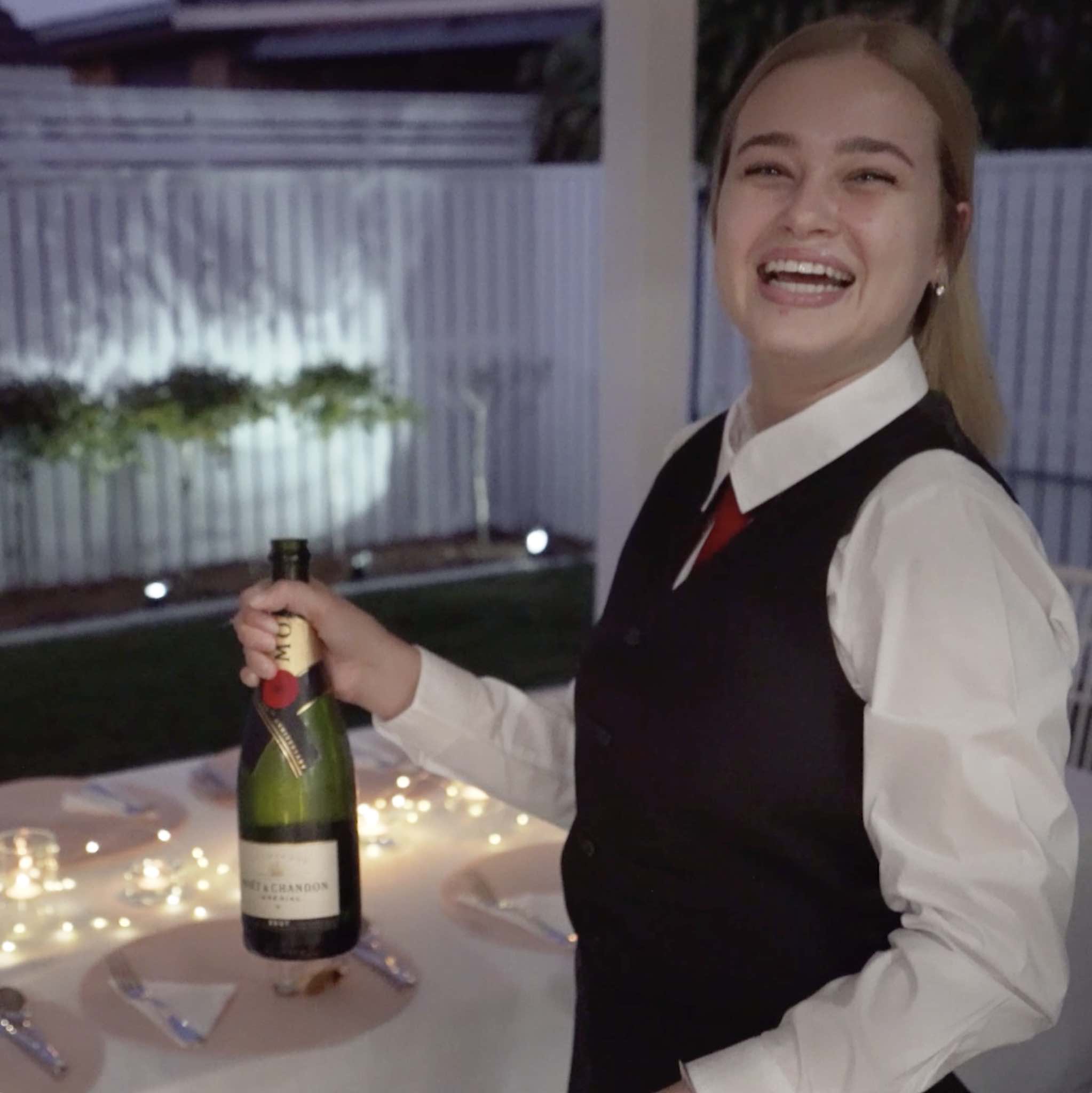 Smiling waitress with bottle of Moet